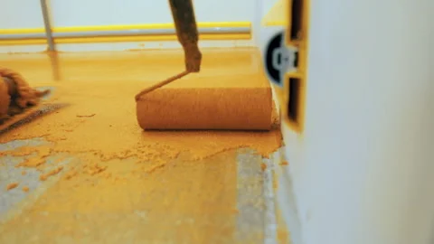 A construction worker apply epoxy resin in an industrial hall Stock Footage 161702878