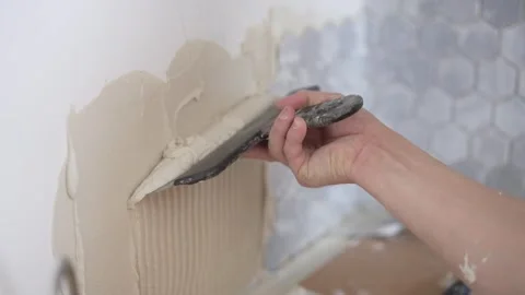 Construction worker applying adhesive to wall Stock Footage 288204949