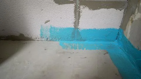 Construction worker applying blue waterproofing tape in a building Stock Photos