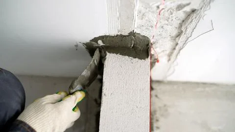Construction worker applying cement on aerated concrete block Stock Photos