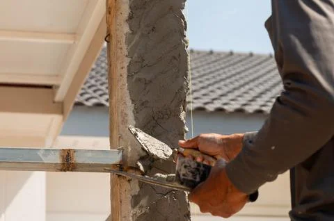 Construction worker applying cement at building site urban environment acti.. Stock Photos