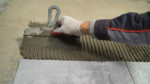 Construction worker applying cement on wall tiles 스톡 사진