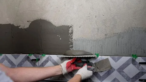 Construction worker applying cement on wall with trowel Stock Photos