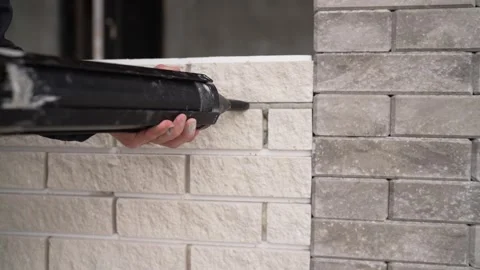 Construction worker applying grout to a decorative brick wall. Video stock 331513596