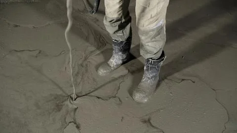 Construction worker applying liquid self leveling compound to prepare floor.. Stock Photos