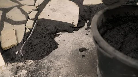 Construction worker applying mortar between paving stones Stock Photos