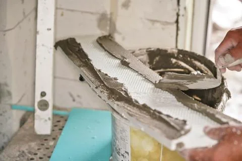 Construction worker applying mortar paste adhesive on insulation foam board.. Stock Photos
