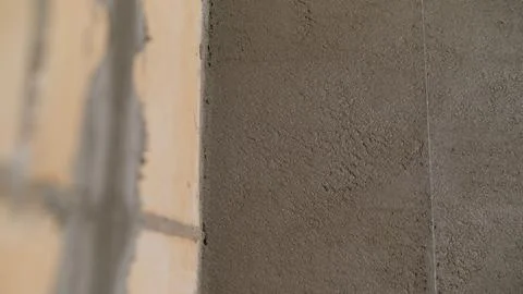 Construction worker applying plaster on a brick wall using a spatula. Stock Photos