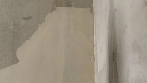 Construction worker applying plaster on concrete wall with trowel Stock Photos