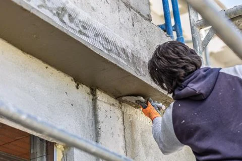Construction worker applying plaster to concrete wall 스톡 사진