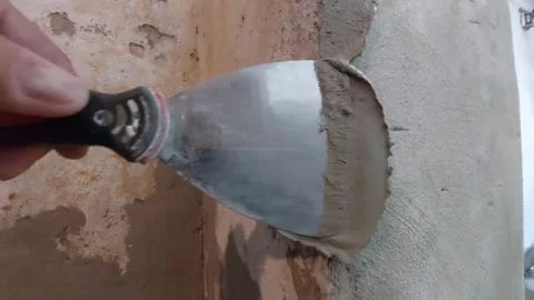 Construction worker applying plaster to an old wall corner with a spatula Stock Footage 337054081