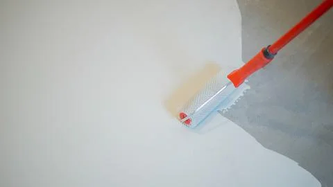 Construction worker applying plaster on a wall using a trowel Stock Photos