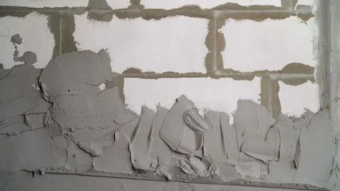 Construction worker applying plaster on white brick wall Stock Photos