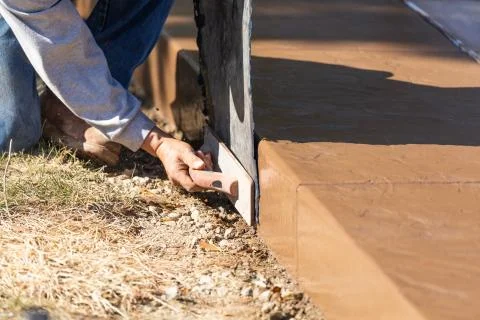 Construction Worker Applying Pressure to Texture Template On Wet Cement Stock Photos