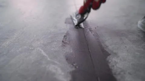 Construction worker applying sealant on concrete floor joint Stock Footage 300803410
