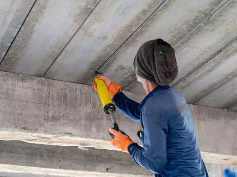 Construction worker applying sealant or polyurethane foam into joint gaps o.. Fotos Stock