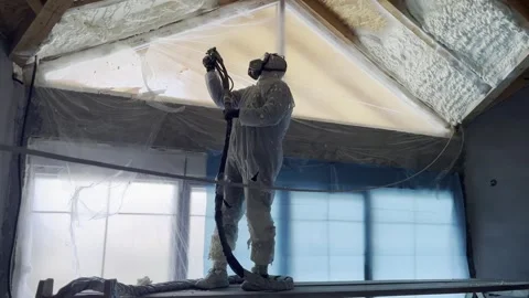 Construction worker applying spray polyurethane foam insulation Stock Footage 323409894