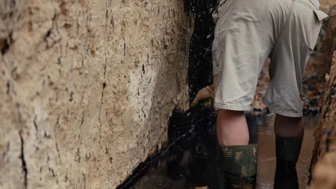 Construction worker applying waterproofing to foundation Stock Footage 341294568