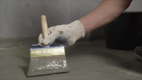Construction worker applying waterproofing material on concrete floor Stock Footage 304030293
