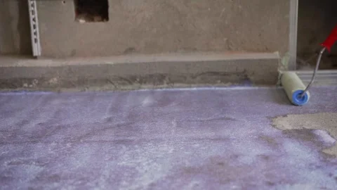 Construction worker applying waterproofing material on concrete floor Stock Footage 314215964