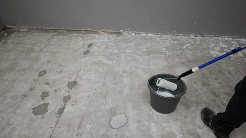 Construction worker applying waterproofing material on concrete surface Stock Photos