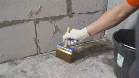 Construction worker applying waterproofing membrane on concrete floor Stock Footage 304044655