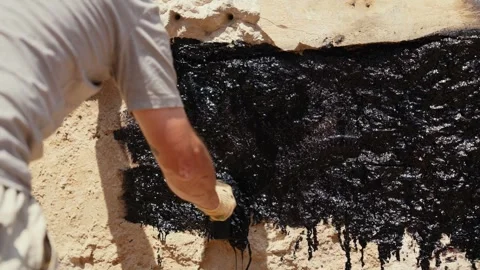 Construction worker applying waterproofing tar to foundation Stock Footage 341294367