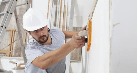 Construction worker are using sponge and plastering trowel to smooth the wall Stock Photos