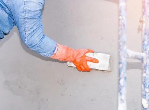 Construction worker are using sponge and plastering trowel to smooth the wall Stock Photos