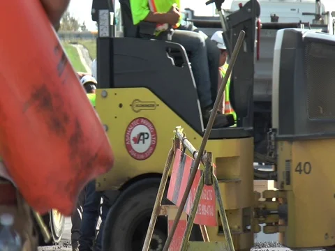 Construction Worker Arrives with Asphalt Roller in Background 스톡 동영상 80207026