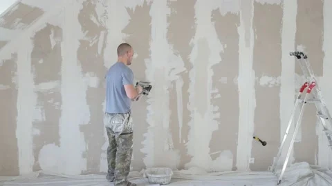 Construction worker assemble and patch plaster wall  fixing the drywall to the Stock Footage 147515112