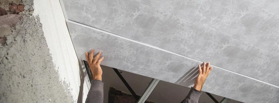 Construction worker assemble a suspended ceiling. Stock Photos