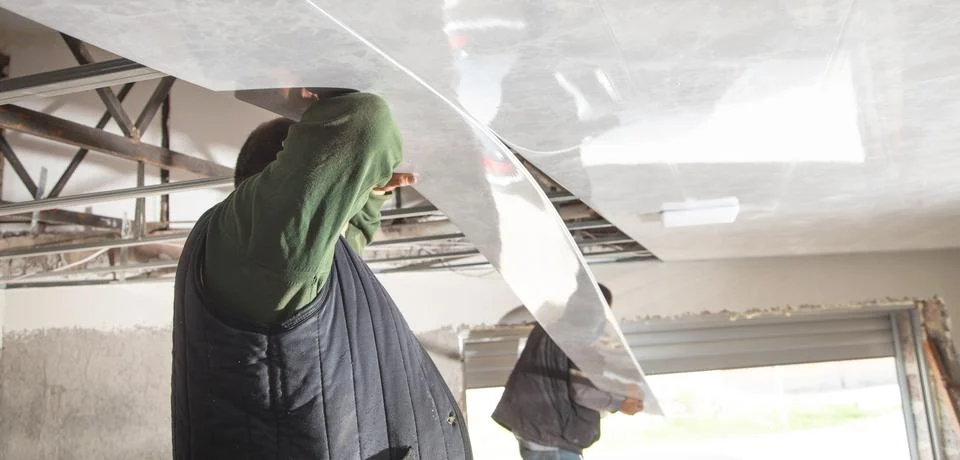 Construction worker assemble a suspended ceiling. Stock Photos