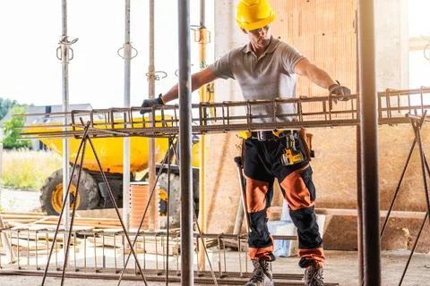 Construction Worker Assembling Rebar at a Building Site During Daylight Photos