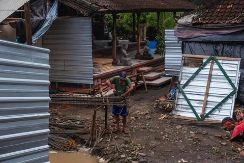 Construction Worker Assembling Steel Rebar on Muddy Site in Bali Stock Photos