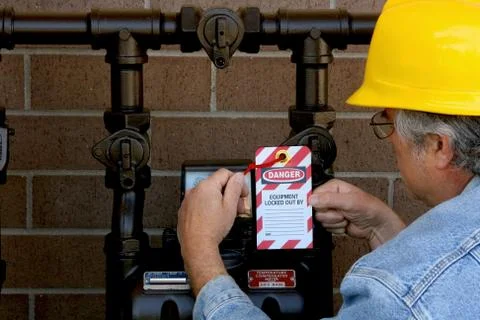 Construction worker attaching a lockout tag to a gas meter Photos