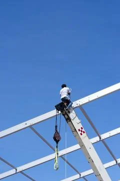 Construction worker balanced on crane boom Fotos de archivo
