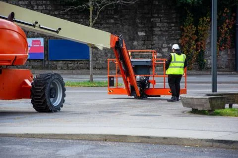 Construction worker beside orange boom lift Stock Photos
