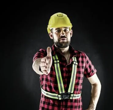 Construction Worker  on black background press the flesh. Stock Photos
