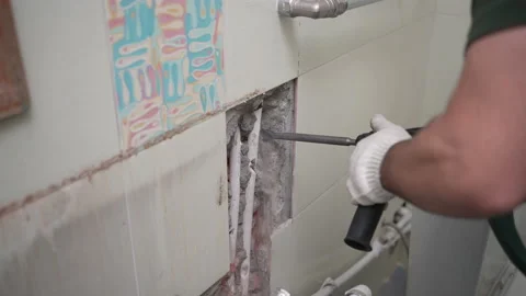 Construction worker breaks the concrete with a large hammer drill. A builder Stock Footage 198662153