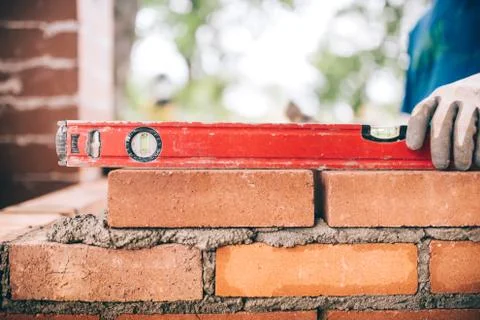 Construction worker, bricklayer or mason laying bricks and creating walls Stock Photos