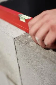 Construction worker, bricklayer or mason laying bricks and creating walls. De Stock Photos