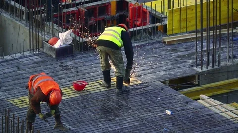 Construction worker in bright vest works with angle grinder. Slow motion Vídeo Stock 72883726