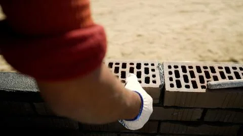 Construction worker building a brick wall using hammer and chisel Foto stock