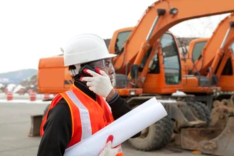 Construction worker with building plans and cellphone Stock Photos