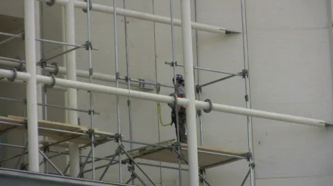 Construction worker building scaffolding high in the duct Stock Footage 408148