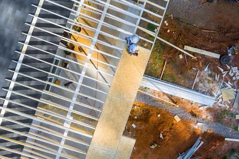Construction worker on building site working on wooden frame structure Stock Photos