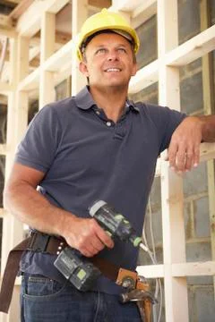 Construction Worker Building Timber Frame In New Home Fotos de archivo
