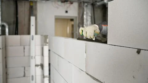 Construction worker building a wall with aerated concrete blocks Stockfoto's