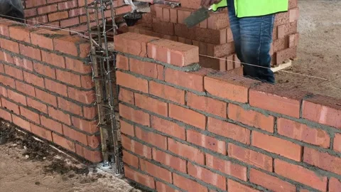 Construction Worker Building Wall with Clay Bricks in Stretcher Bond Pattern Stock Footage 334393464